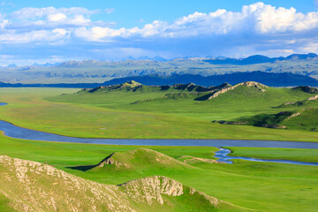 Bayinbuluke grassland natural scenery in Xinjiang,China.The winding river is on the green grassland.