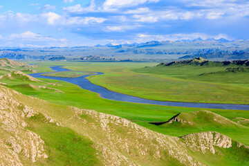 Fototapeta na wymiar Bayinbuluke grassland natural scenery in Xinjiang,China.The winding river is on the green grassland.
