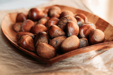 Close up of raw chestnuts in wooden dish. Autumn vibes