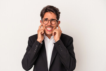 Young mixed race business man isolated on white background covering ears with hands.