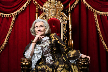 Fototapeta premium Portrait of a surprised beautiful senior queen on throne