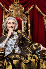 Fototapeta premium Portrait of a surprised beautiful senior queen on throne
