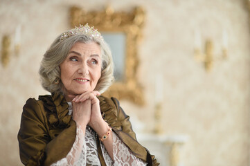 Portrait of a beautiful senior woman Queen, indoors