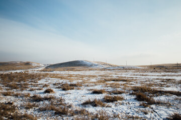 Natural winter landscape with field and mountains in the background in Khakassia