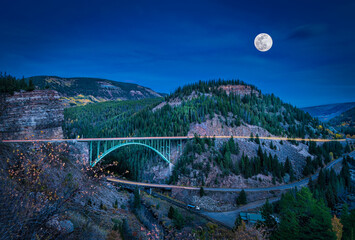 full moon over mountain bridge at Blue Hour