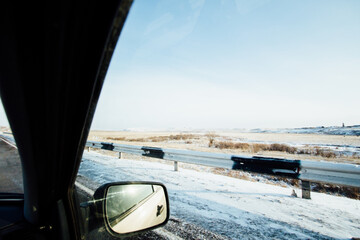 Travel by car in winter Khakassia with a view of the field and road fence