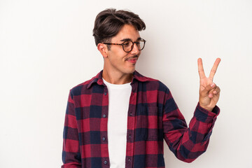 Young mixed race man isolated on white background joyful and carefree showing a peace symbol with...
