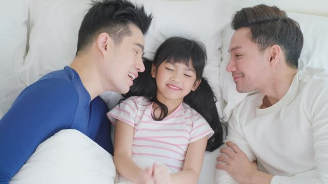 Portrait of handsome man gay family with young kid daughter in bedroom