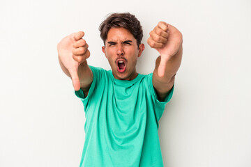 Young mixed race man isolated on white background showing thumb down and expressing dislike.