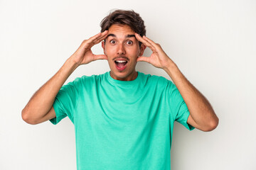 Naklejka premium Young mixed race man isolated on white background receiving a pleasant surprise, excited and raising hands.