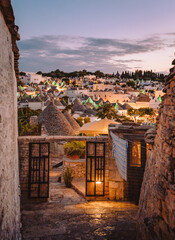 View of the Trulli of Alberobello at sunset with city lights