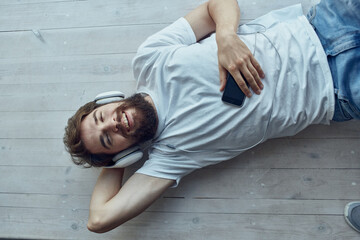 bearded man lying on the windowsill wearing headphones Lifestyle