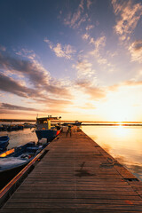 Obraz na płótnie Canvas Taranto Vecchia pier at dawn with orange sky with clouds and moored boats