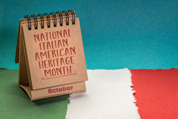 October - National Italian American Heritage Month, handwriting in a desktop calendar against paper abstract in colors of national flag of Italy (green, white and red), reminder of cultural event