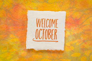 Welcome October greeting note  - handwriting on a handmade rag paper against marbled paper, calendar concept