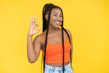 Okay gesture. Agreement sign. Good idea. Satisfied happy African woman showing ok approval hand symbol isolated on orange background.