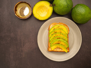 The toast then topped pepper with sliced avocado, salt, and cayenne pepper. Avocados are a versatile fruit to slice, mash, or fill. Top view. Space for text. Health fruit concept