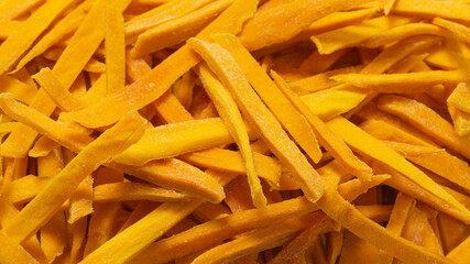 Dry tasty mango slices as a background.