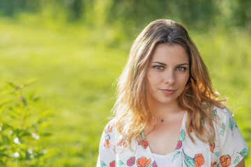 Naklejka premium Portrait of beautiful young woman posing outdoors. Horizontally. 