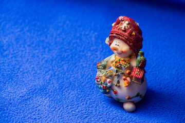 A toy snowman with a lantern is waiting for Christmas and New Year