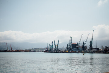 Port view with cranes by the sea with large clouds in the background