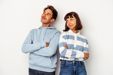 Young mixed race couple isolated on white background dreaming of achieving goals and purposes