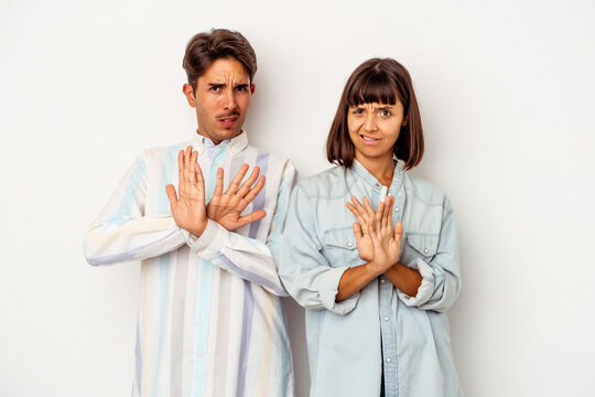 Young Mixed Race Couple Isolated On White Background Doing A Denial Gesture