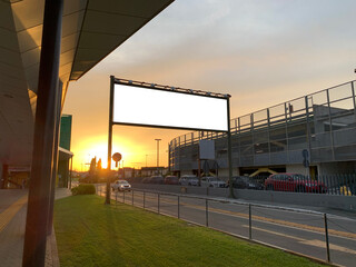 View of a road billboard in the sunset with white space mockup