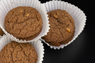 Delicious tasty snack of brown cookies with chocolate chip and peanut isolated on black background