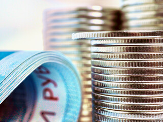 Piles of Russian coins and a fragment of a banknote of 2000 rubles close-up. News about the...