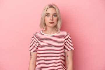 Young caucasian woman isolated on pink background sad, serious face, feeling miserable and displeased.