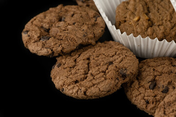 Delicious tasty snack of brown cookies with chocolate chip and peanut isolated on black background