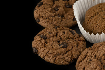 Delicious tasty snack of brown cookies with chocolate chip and peanut isolated on black background