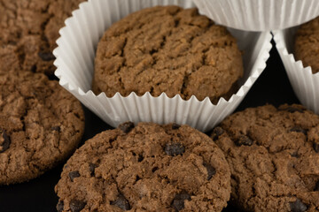 Delicious tasty snack of brown cookies with chocolate chip and peanut isolated on black background