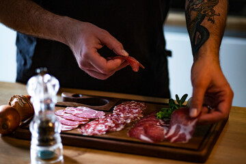 Food concept; Chef decorate ready dish with slices salami.
Young man with tattoo decorate delicious...