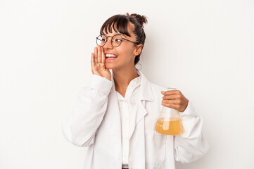 Young mixed race scientist woman holding a test tube isolated on white background  shouting and holding palm near opened mouth.