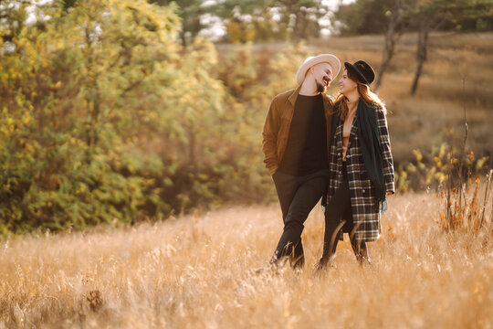 Romantic couple in love walking  in the autumn park. Love story. Autumn style. Kiss and hugs.