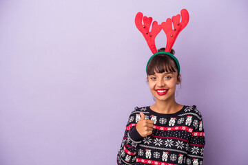 Young mixed race woman with reindeer hat celebrating Christmas isolated on purple background  smiling and raising thumb up