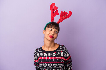Young mixed race woman with reindeer hat celebrating Christmas isolated on purple background  dreaming of achieving goals and purposes