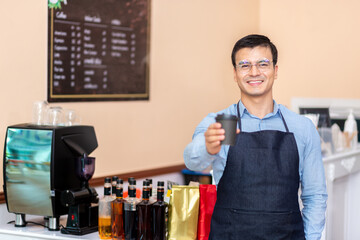 Business owner. A cheerful successful small business owner standing with his arms crossed smiles