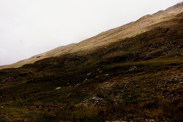 Hill side in Connemara Ireland. A grassy slope in the shade and the top part is sunny. Overcast day, no rain. 
