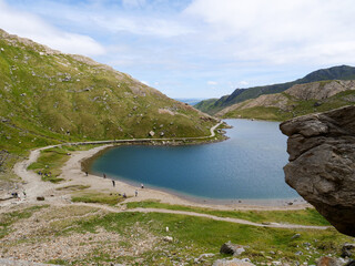Hikers relaxing by Glaslyn lake at the foot of Mount Snowdon in Snowdonia National Park of Wales, UK.