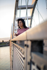 Beautiful young woman enjoy in sunset on the city bridge.