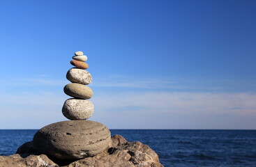 Zen stones. Zen stone pyramid illuminated by the rays of the evening sun against the background of...