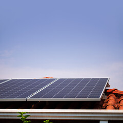 Solar panels on the red roof in a sunny and cloudy day. Photovoltaic instalation image.