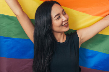 Happy woman smiling and standing with pride flag. Gender Equality and LGBTQ concept.