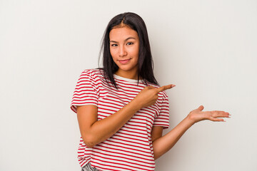 Young latin woman isolated on white background  excited holding a copy space on palm.