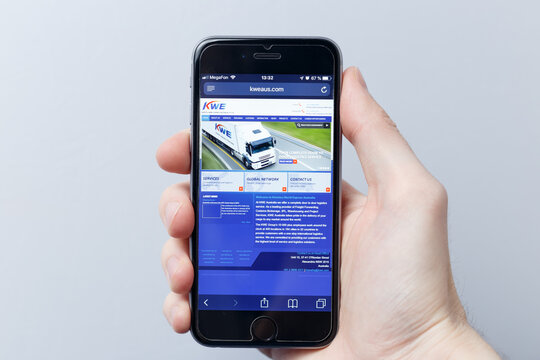 Moscow / Russia - 04.21.2019: A hand holding a smartphone which displays Kintetsu World Express logo on the official website homepage. KWE logo visible on smartphone screen. Illustrative editorial