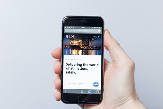 Moscow / Russia - 04.21.2019: A hand holding a smartphone which displays BDP International logo on the official website homepage. logo visible on smartphone screen. Illustrative editorial