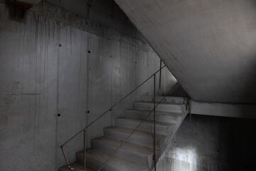 concrete staircase between floors of a building under construction. Concrete walls and ceilings, construction site.